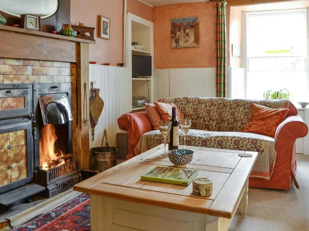 a living room with a couch and a fireplace at Larch Cottage in Balnald