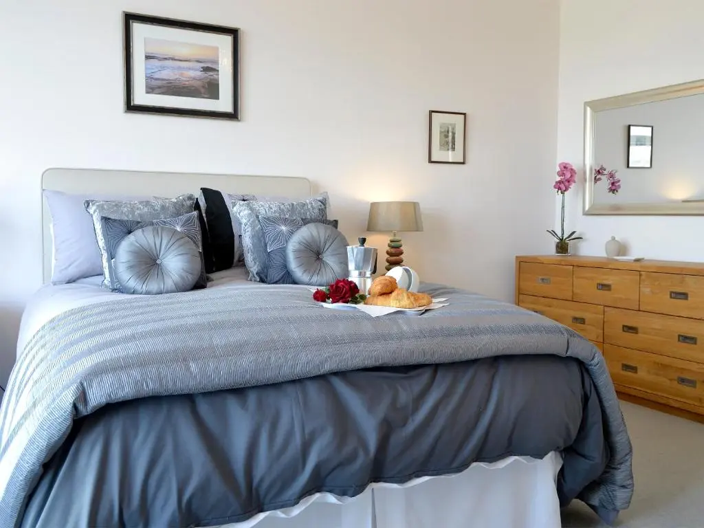 a bedroom with a bed with a tray of fruit on it at Seascape in Whitehills