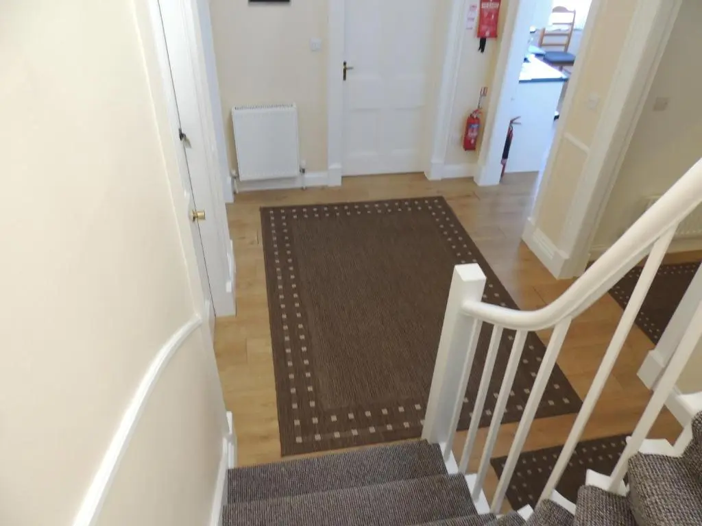 a hallway with a staircase with a rug on the floor at 5A Union Road in Macduff