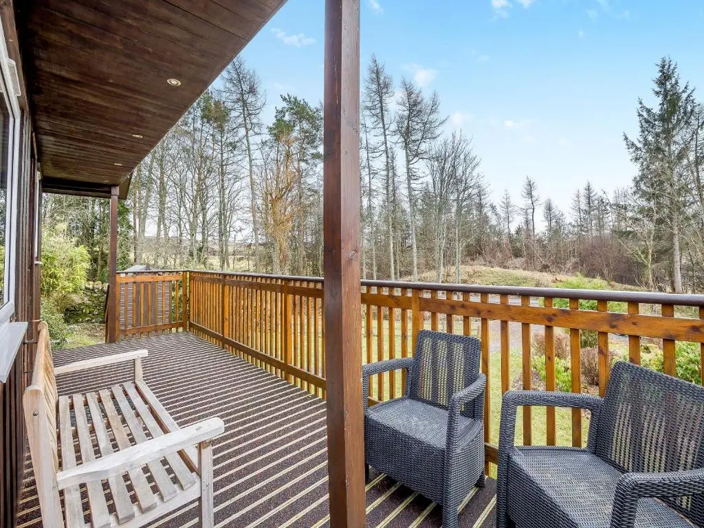 a screened porch with two chairs and a table at Boreland Farm Cabin - Uk5855 in Kirkmichael