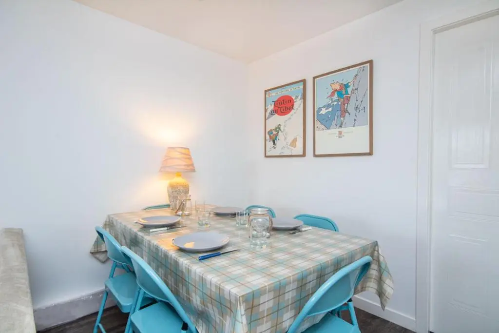 a table with blue chairs and a table cloth on it at Aviemore Highlands No82 in Aviemore