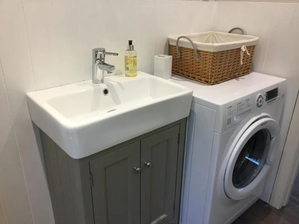 a bathroom with a sink and a washing machine at Aviemore Highlands No82 in Aviemore