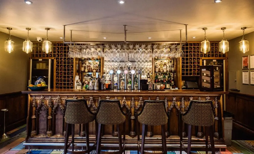 a bar with four chairs sitting at a bar at Banchory Lodge Hotel in Banchory