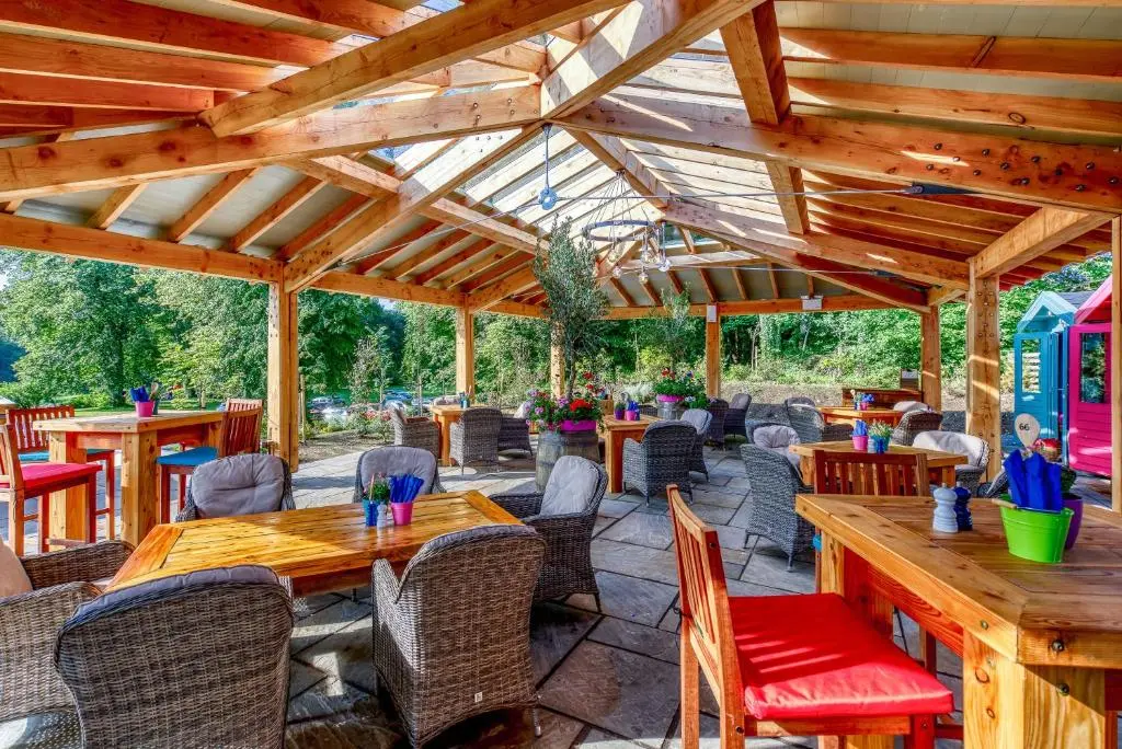 an outdoor patio with wooden tables and chairs at Banchory Lodge Hotel in Banchory