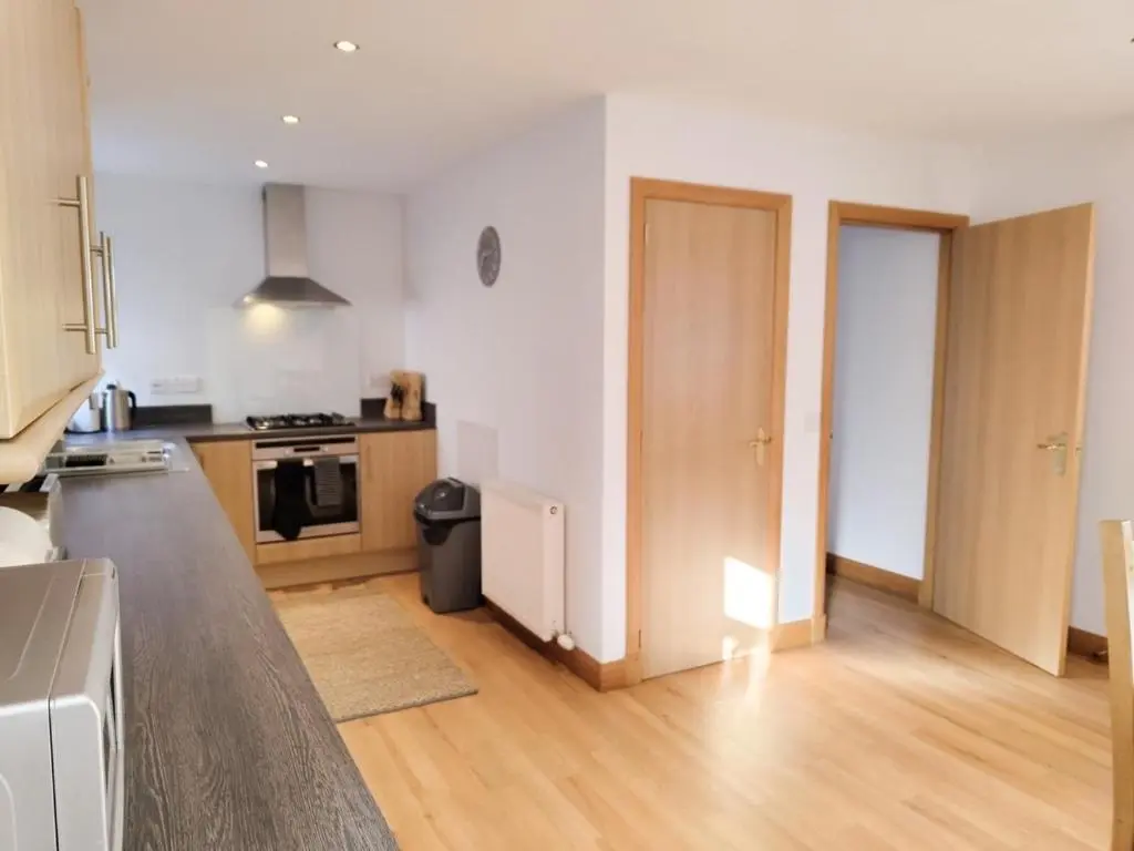 a kitchen with wooden floors and an open door at Portknockie 17 Harbour Place in Portknockie