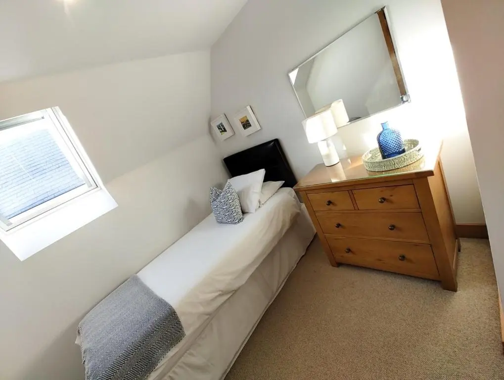 a bedroom with a bed with a dresser and a mirror at Portknockie 17 Harbour Place in Portknockie