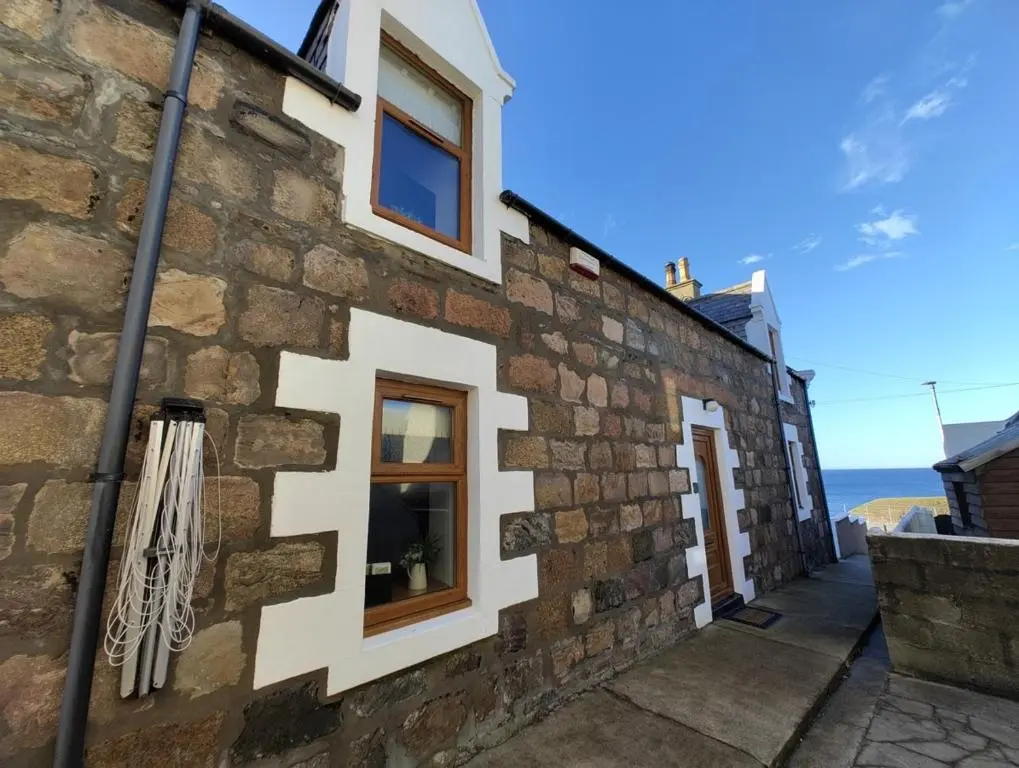 a stone building with windows on the side of it at Portknockie 17 Harbour Place in Portknockie