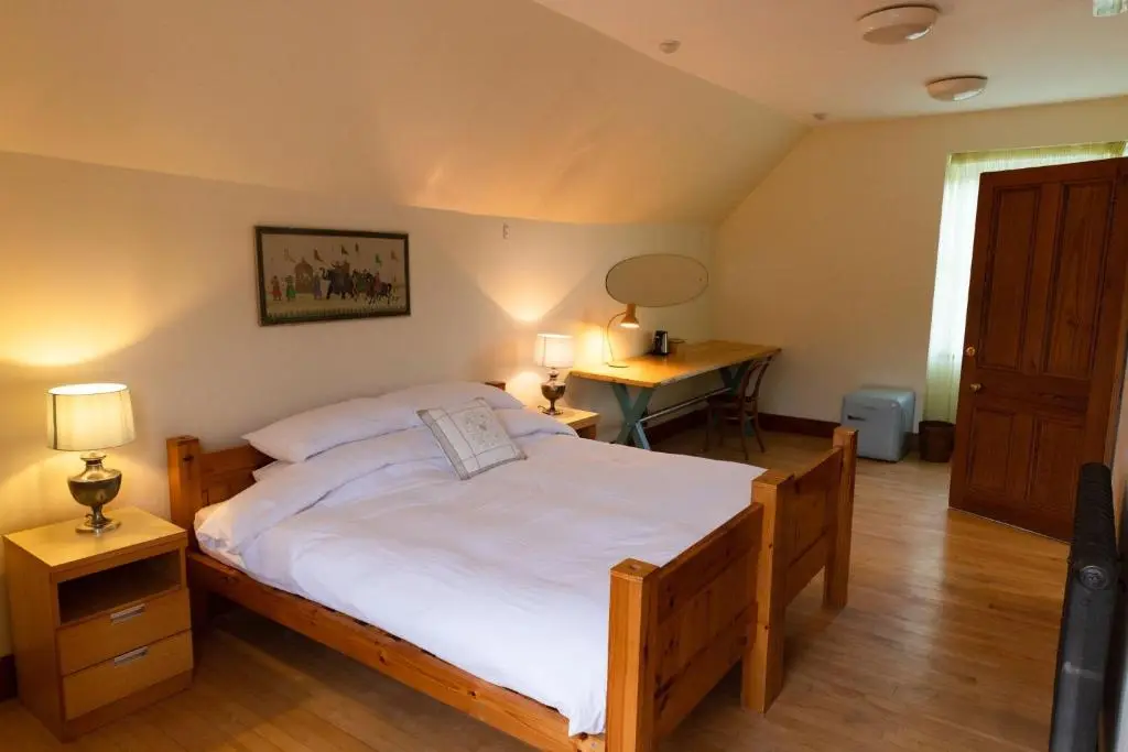 a bedroom with a large bed and a desk at Schoolhouse in Ballater