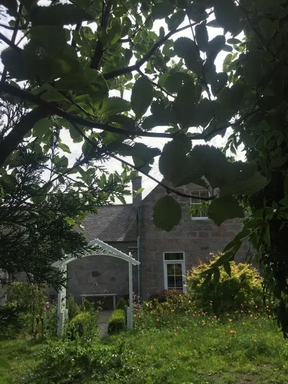 a stone house with a window in the yard at Schoolhouse in Ballater
