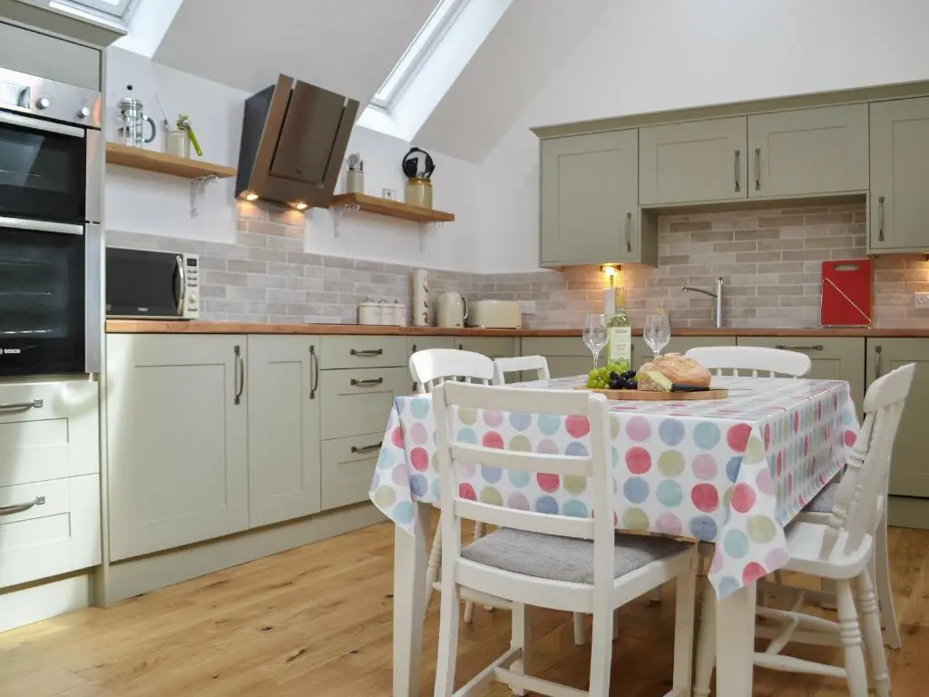 a kitchen with a table with a polka dot table cloth at Wester Laggan Cottage in Skye of Curr