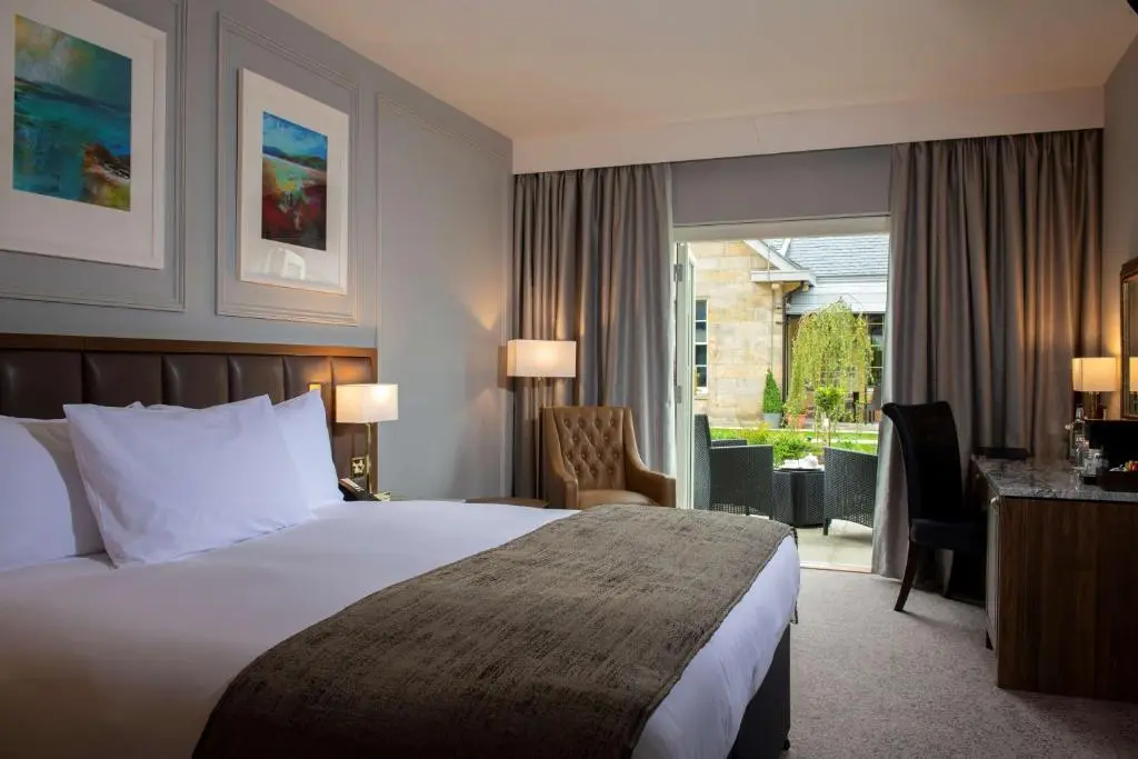 a hotel room with a bed and a desk and a window at Ness Walk in Inverness