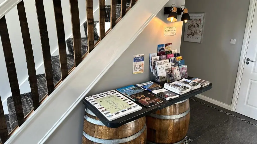 a stair case with a table with wine barrels at The Gables Whisky B&B in Dufftown