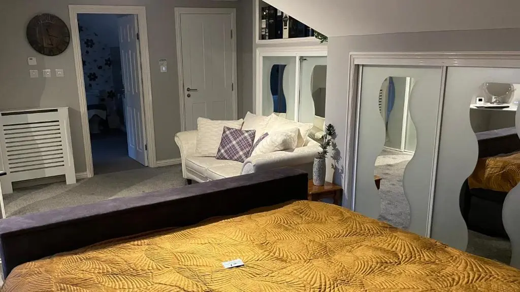 a bedroom with a bed and a couch at The Gables Whisky B&B in Dufftown