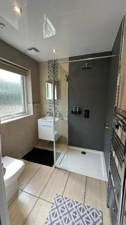 a bathroom with a shower and a toilet and a sink at The Gables Whisky B&B in Dufftown