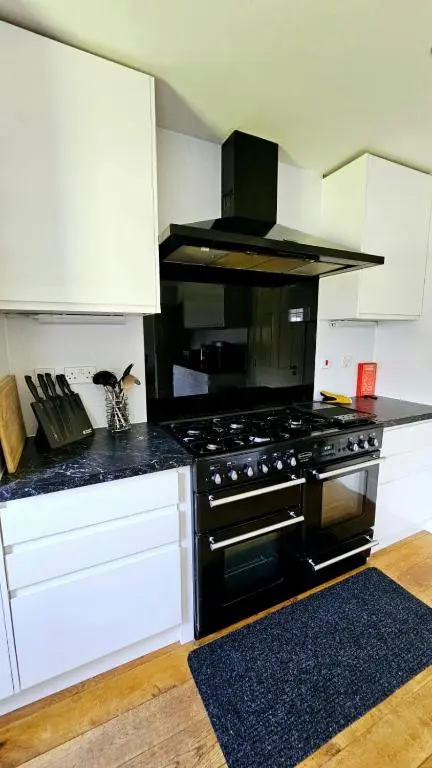 a kitchen with a black stove and white cabinets at 26 Woodgrove Drive in Inverness