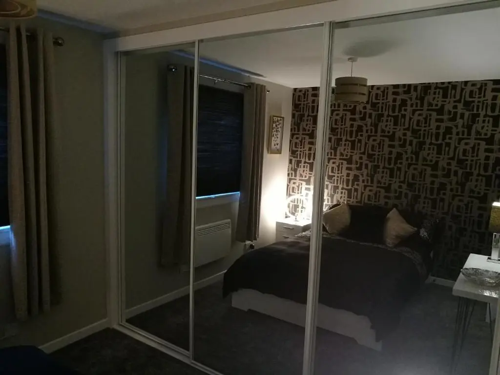 a bedroom with a bed and a glass wall at The Hedgehogs in Inverness