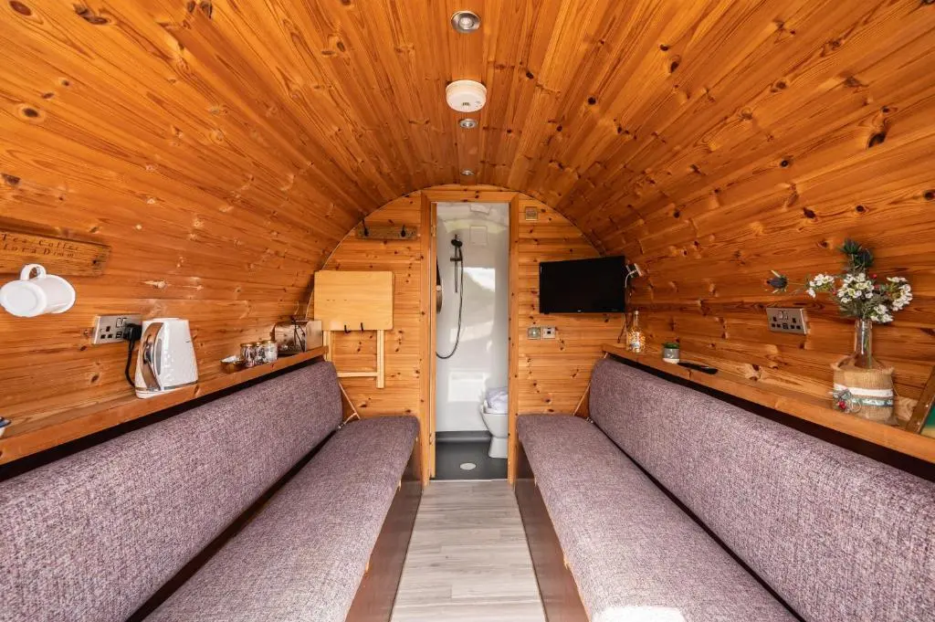 a bathroom with two benches and a toilet at Delny Glamping and Farm Animals in Invergordon