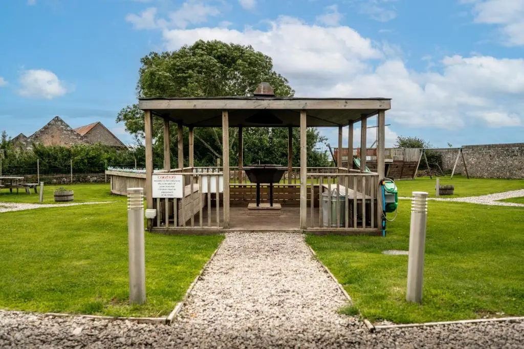 a gazebo with a grill in a park at Delny Glamping and Farm Animals in Invergordon