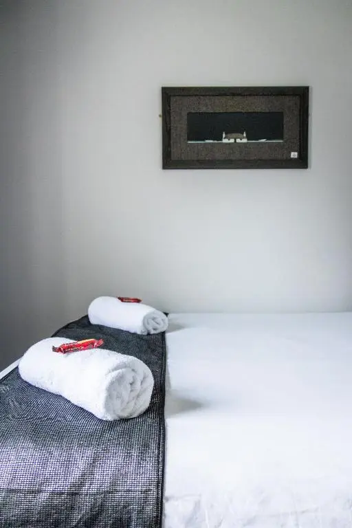 a bedroom with two towels on a bed at Bazpackers in Inverness