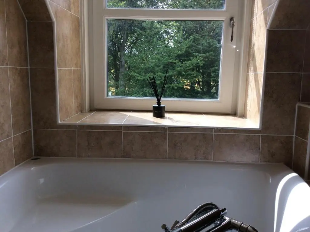 a bath tub in a bathroom with a window at Craig Cottage in Banff