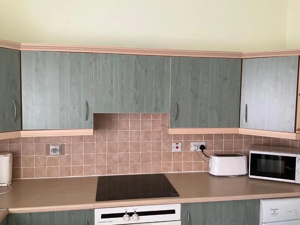 a kitchen with gray cabinets and a counter top at Courtyard Cottage Free Parking in Inverness