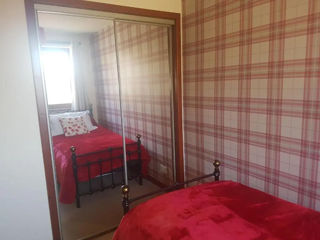a bedroom with a mirror and a bed in it at Culduthel Vista Apartment in Inverness