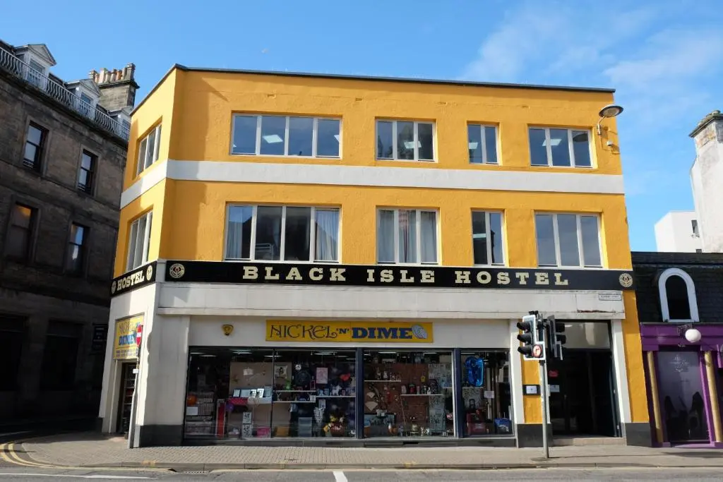 a yellow building on the corner of a street at Black Isle Hostel in Inverness