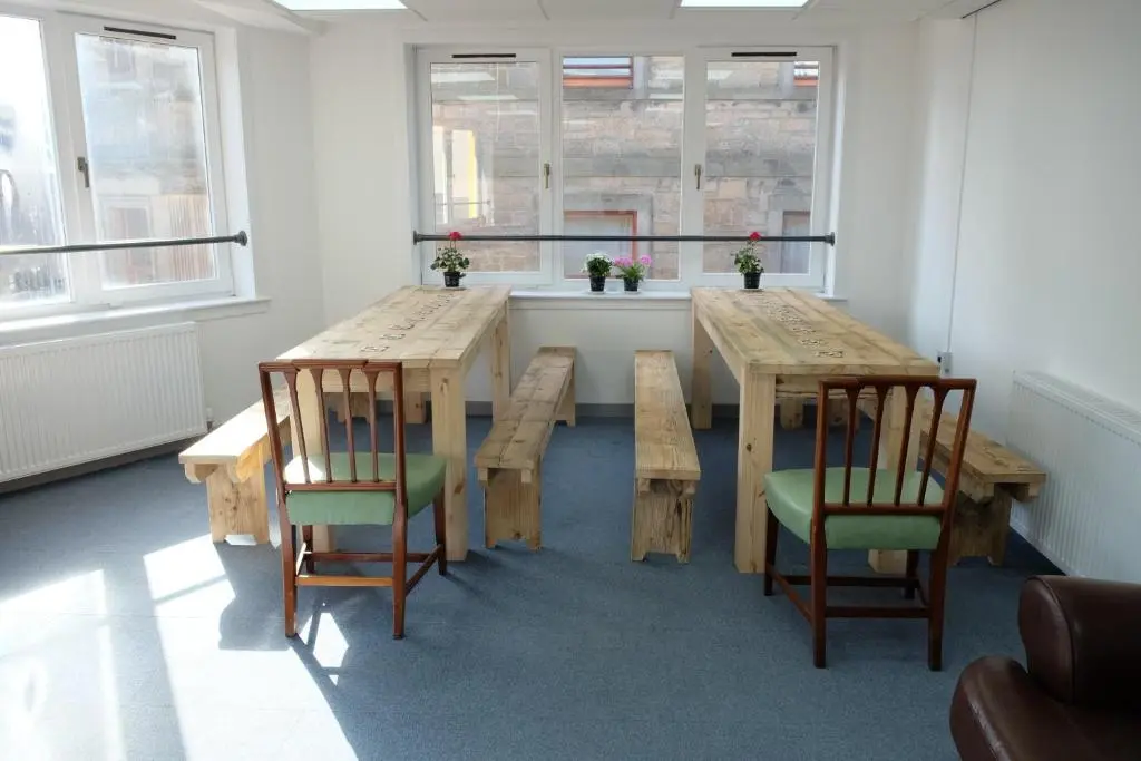 a dining room with two wooden tables and chairs at Black Isle Hostel in Inverness