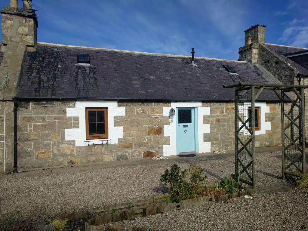 an old stone cottage with a blue door at 6 Seatown, Lossiemouth in Lossiemouth