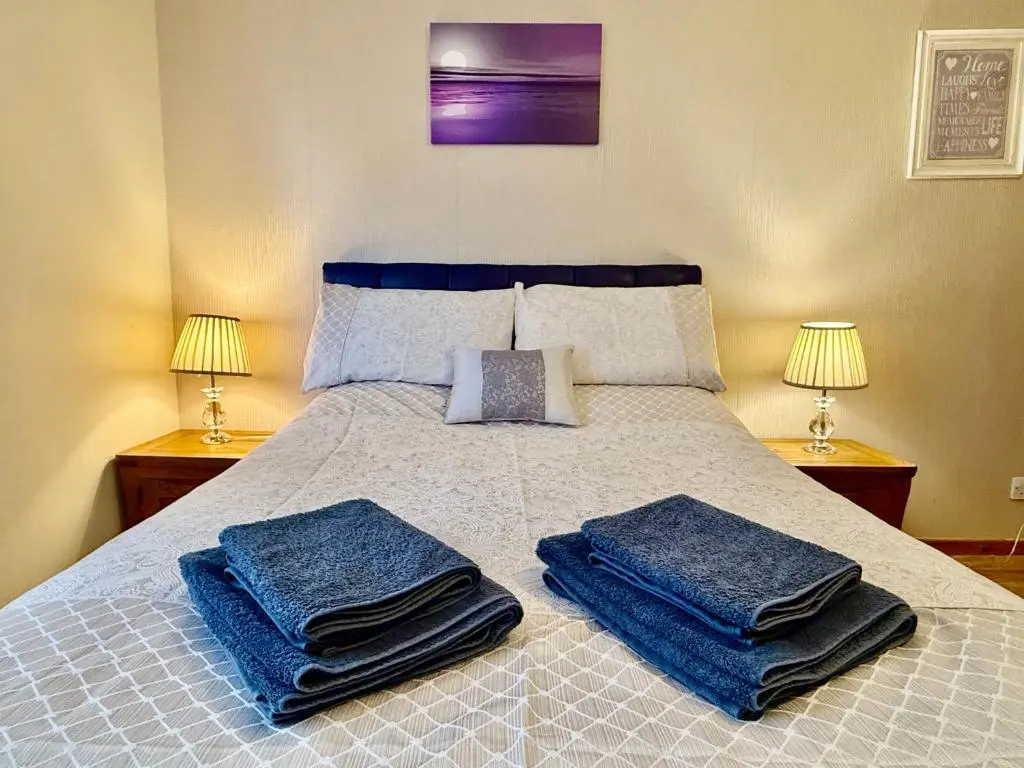 a bedroom with a bed with blue towels on it at Azim and Suzi\u2019s city centre apartment Inverness in Inverness