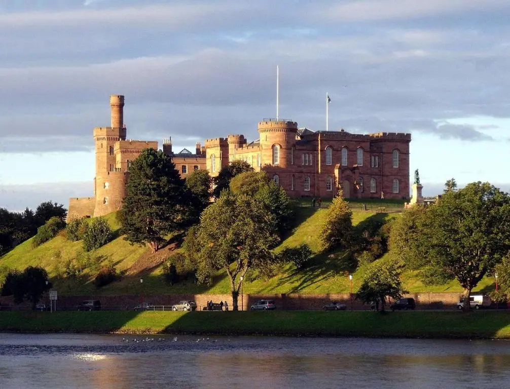 a castle on top of a hill next to a body of water at Azim and Suzi\u2019s city centre apartment Inverness in Inverness
