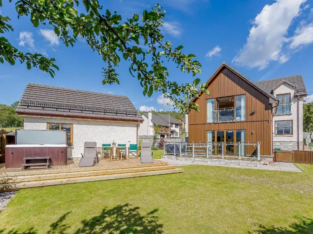 a house with a backyard with a table and chairs at The Lookout in Aviemore
