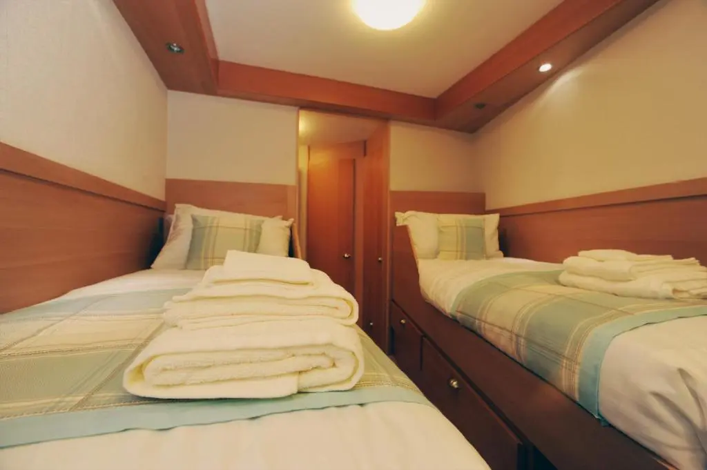 a room with two beds with towels on them at The Boat and Breakfast in Inverness