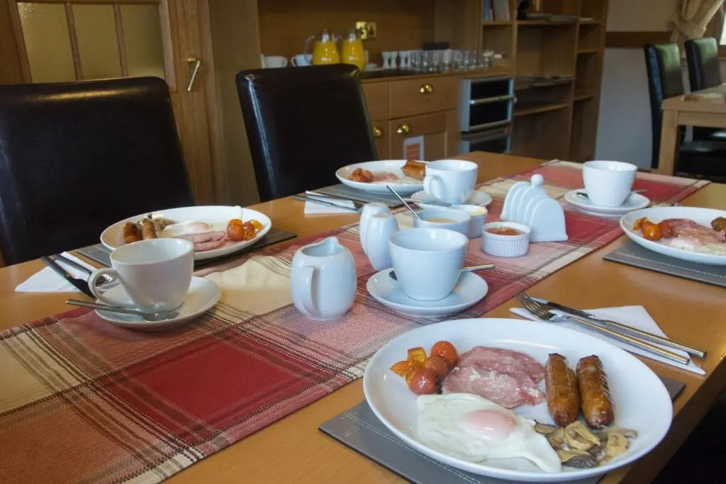 a wooden table with plates of food on it at The Boat and Breakfast in Inverness