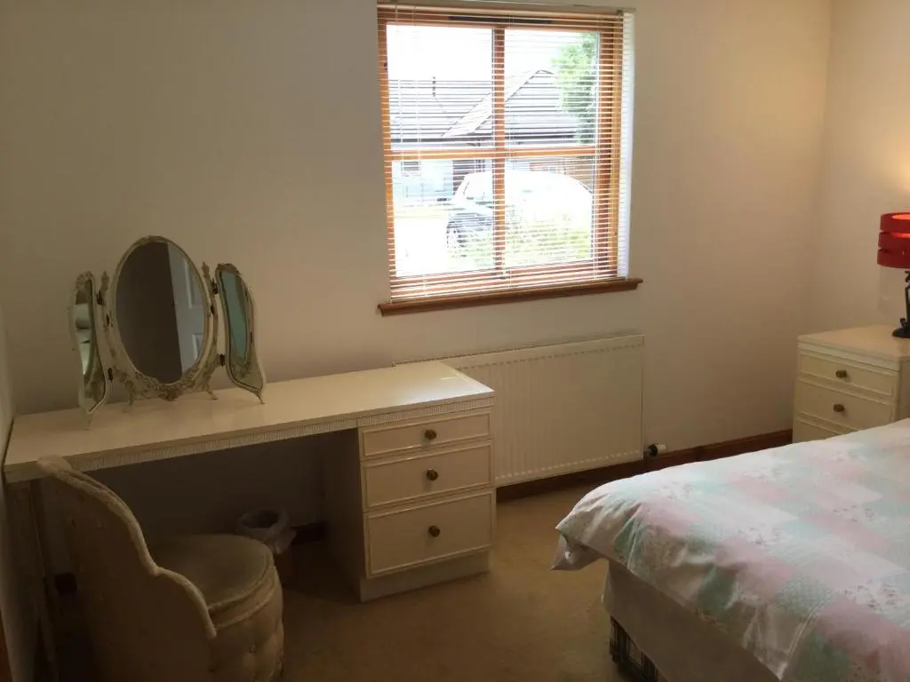 a bedroom with a dressing table and a mirror at Two-Bedroom Apartment - Golf View Free Parking in Inverness
