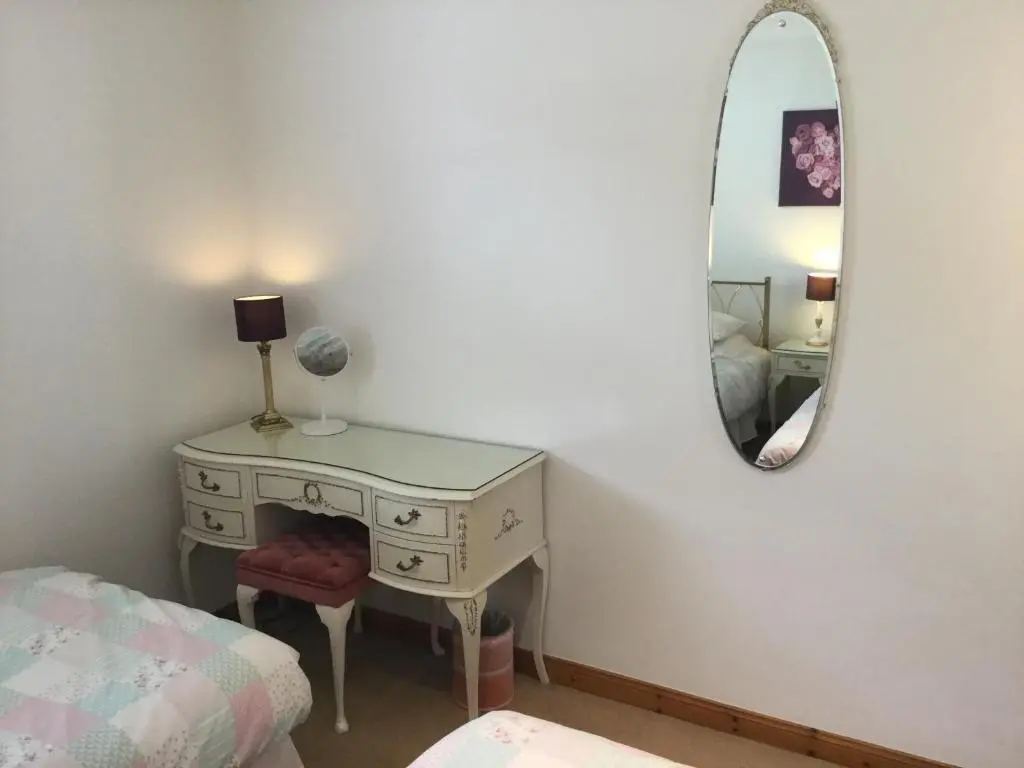a bedroom with a dressing table and a mirror at Two-Bedroom Apartment - Golf View Free Parking in Inverness