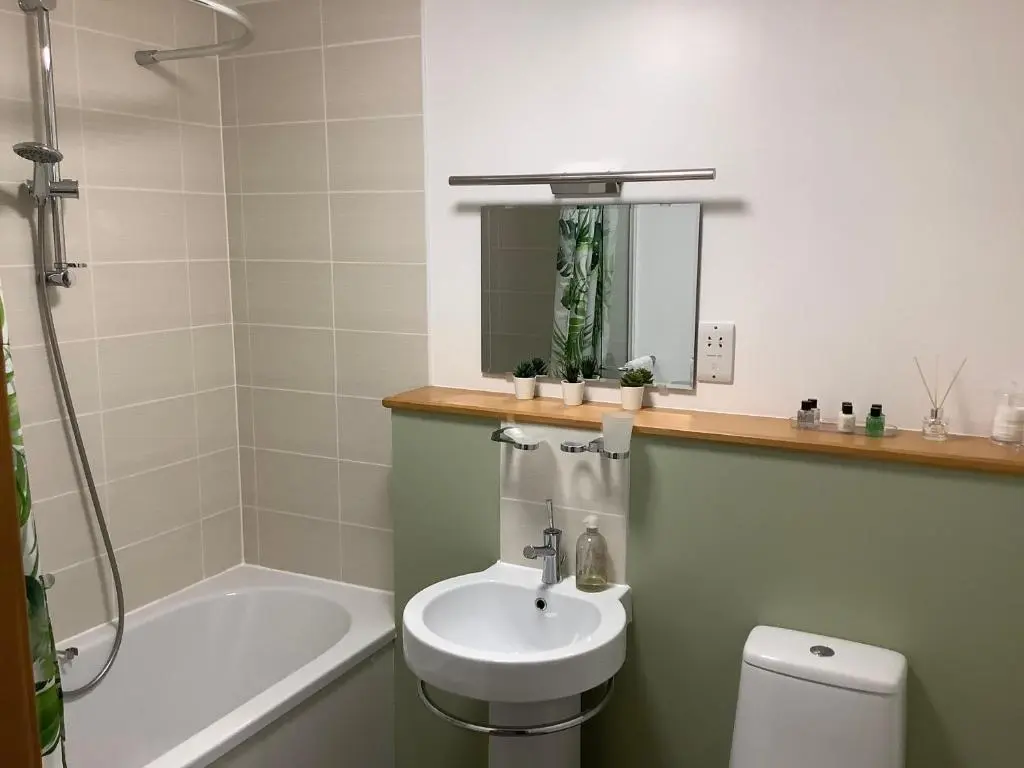 a bathroom with a sink and a toilet and a bath tub at 37 Farraline Court, City Centre apartment in Inverness