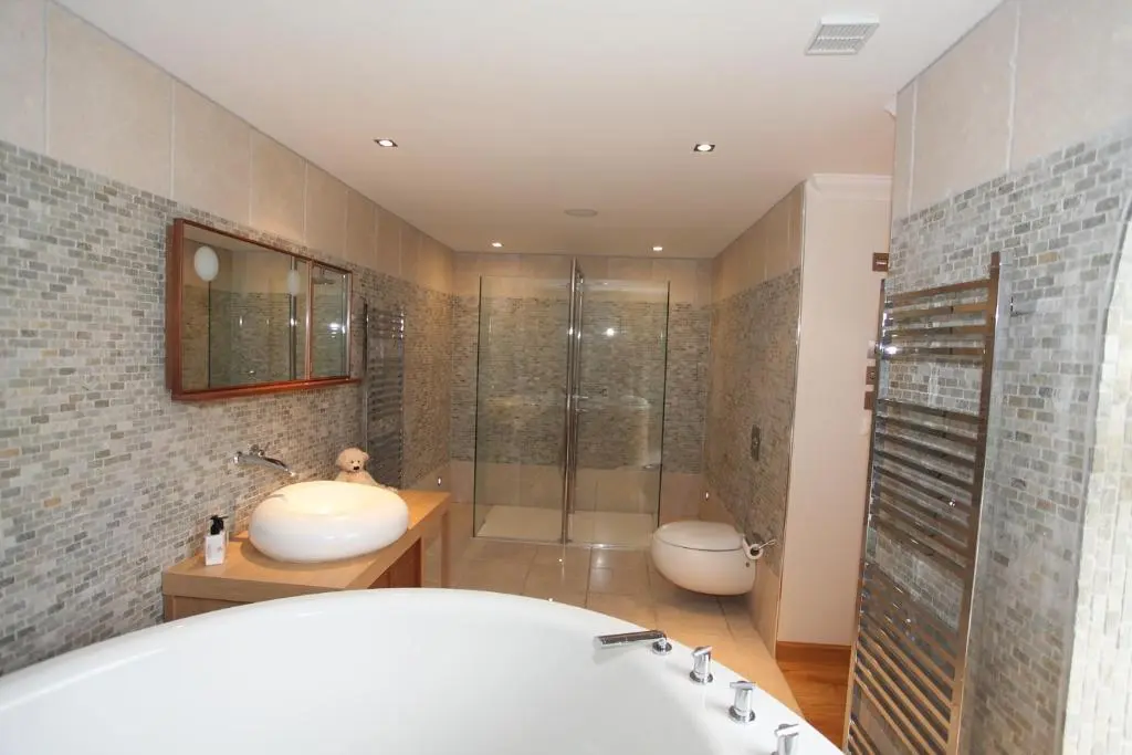 a bathroom with a shower and a tub and a sink at Craig Alvah Lodge in Banff