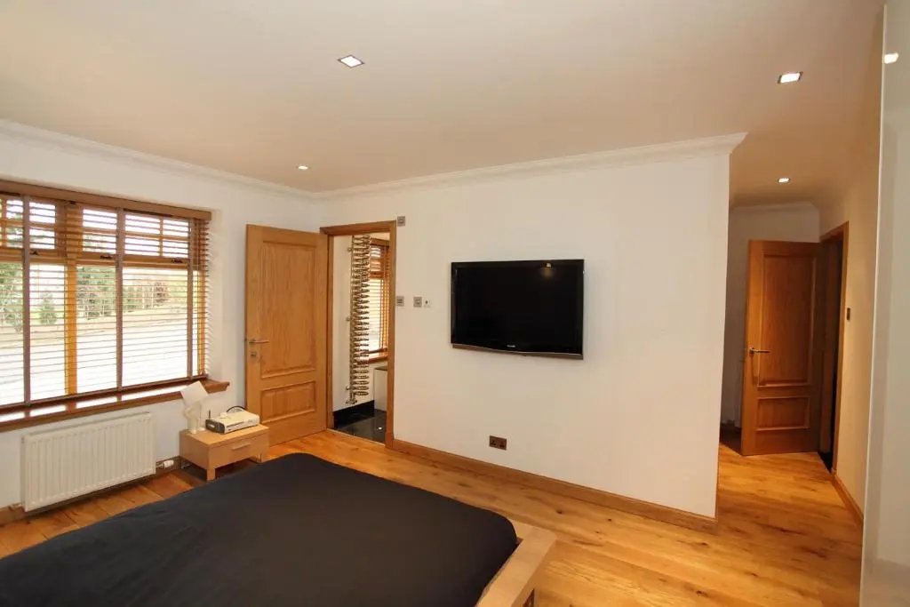 a bedroom with a flat screen tv on a wall at Craig Alvah Lodge in Banff