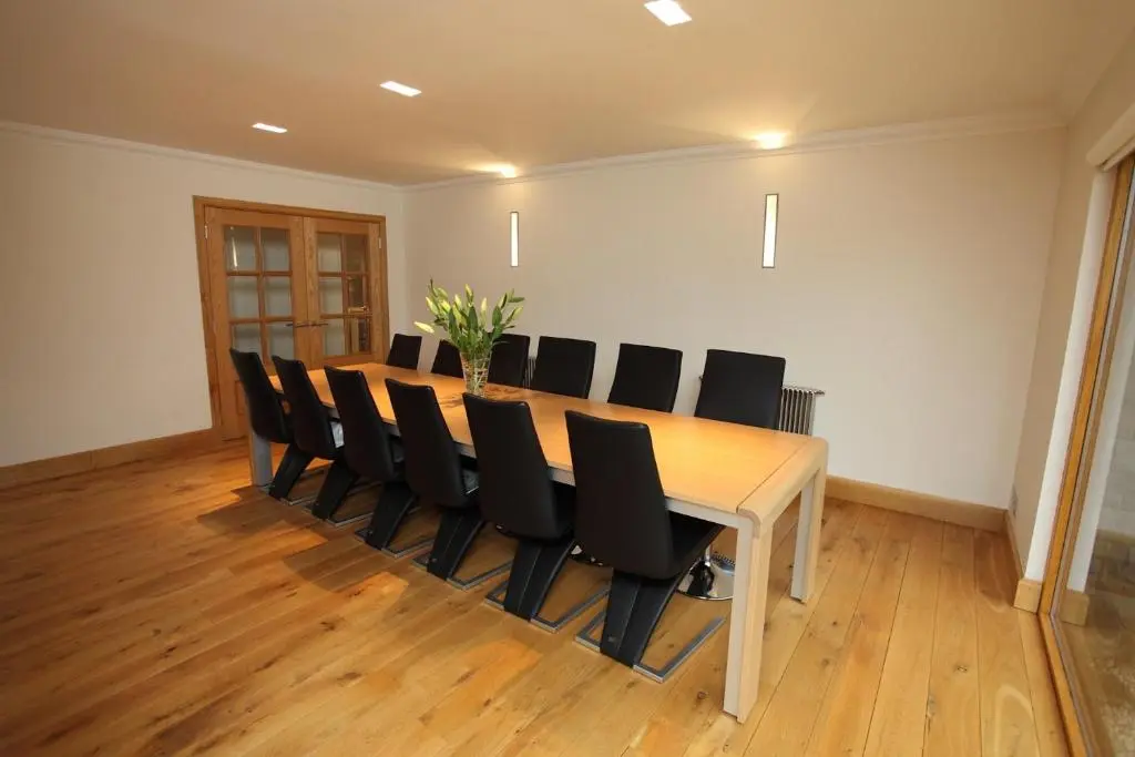 a conference room with a wooden table and black chairs at Craig Alvah Lodge in Banff