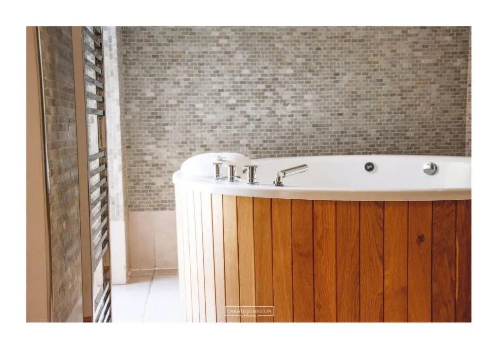 a bath tub in a bathroom with a wooden cabinet at Craig Alvah Lodge in Banff