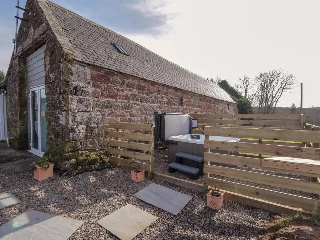 a backyard with a brick building and a bath tub at Milltown House in Turriff