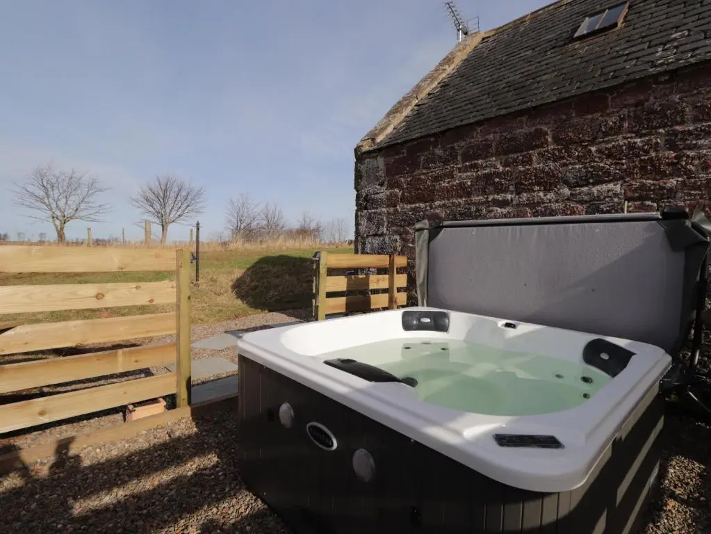 a bath tub sitting next to a brick building at Milltown House in Turriff