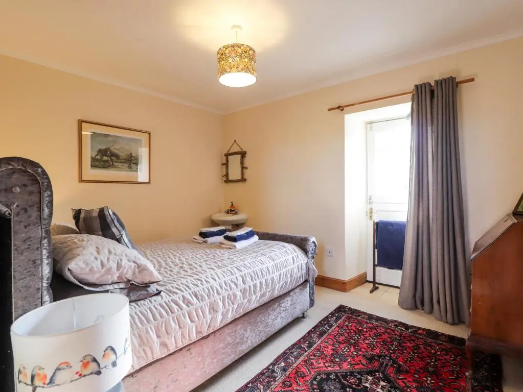 a bedroom with a bed and a window at Milltown House in Turriff