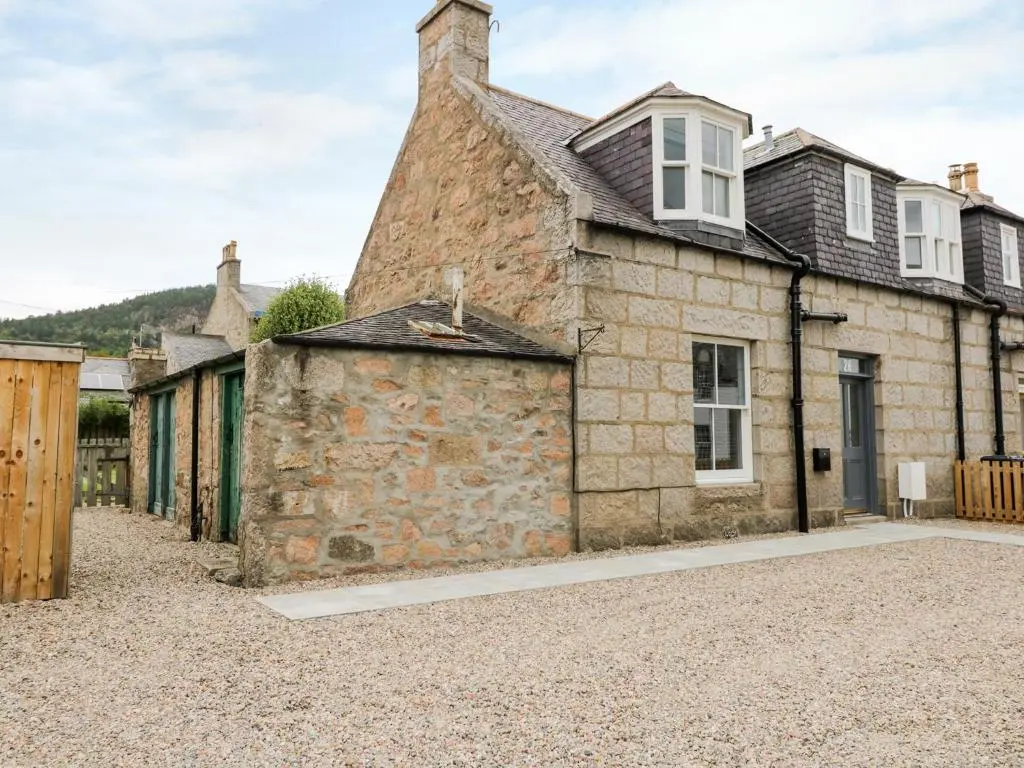 an old stone house with a gravel driveway at Westwood in Ballater