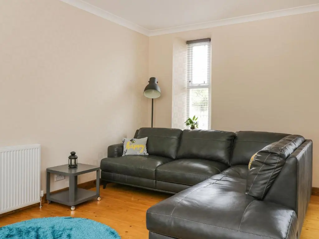 a living room with a leather couch and a table at Westwood in Ballater