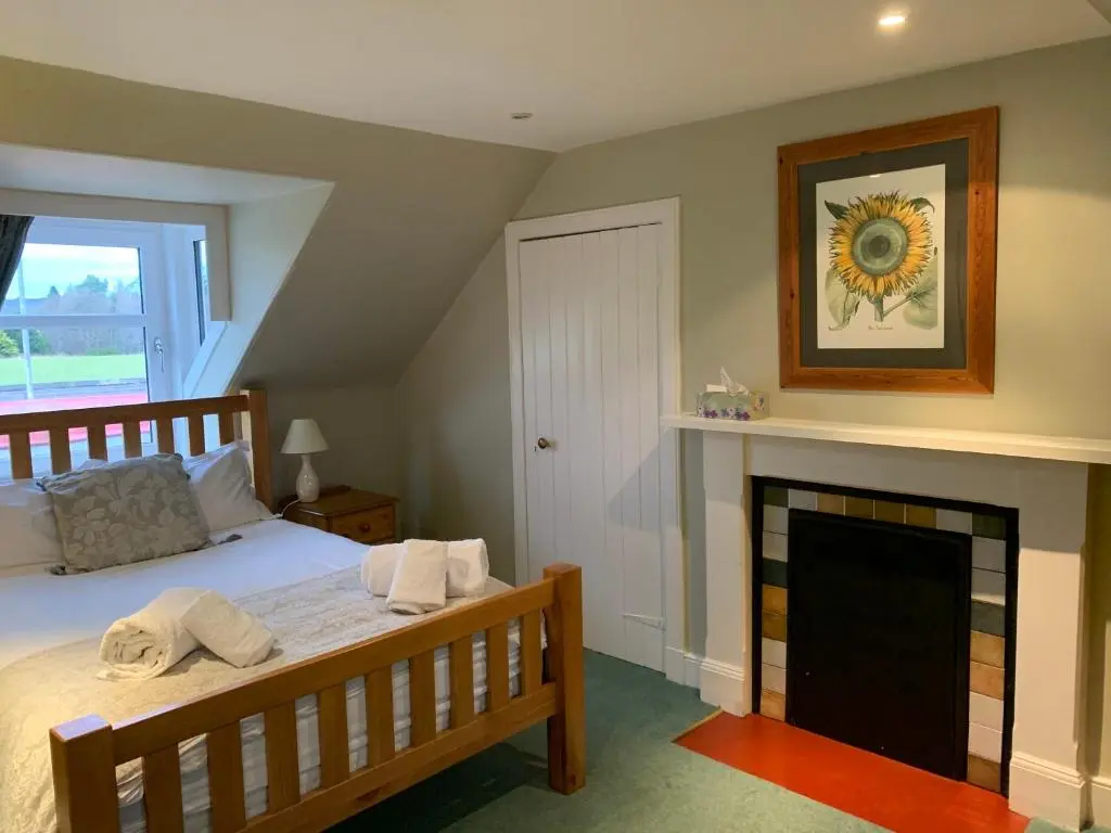 a bedroom with a bed and a fireplace at The Cottage Aberlour in Aberlour
