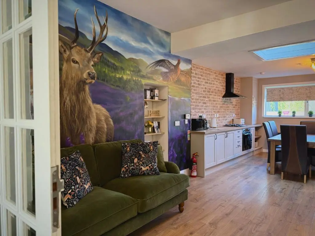 a living room with a painting of a deer on the wall at Wells Street Cottages No 26 By The River Ness in Inverness