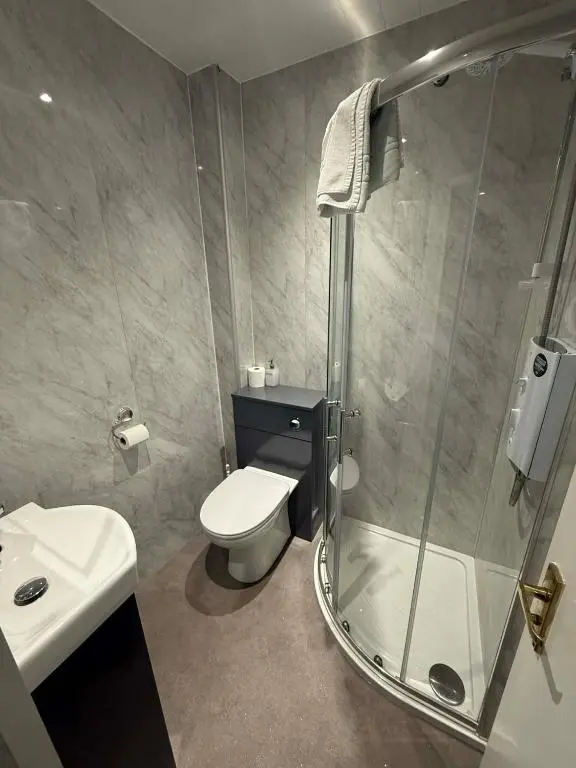 a bathroom with a shower and a toilet and a sink at The Carisbrooke in Forres