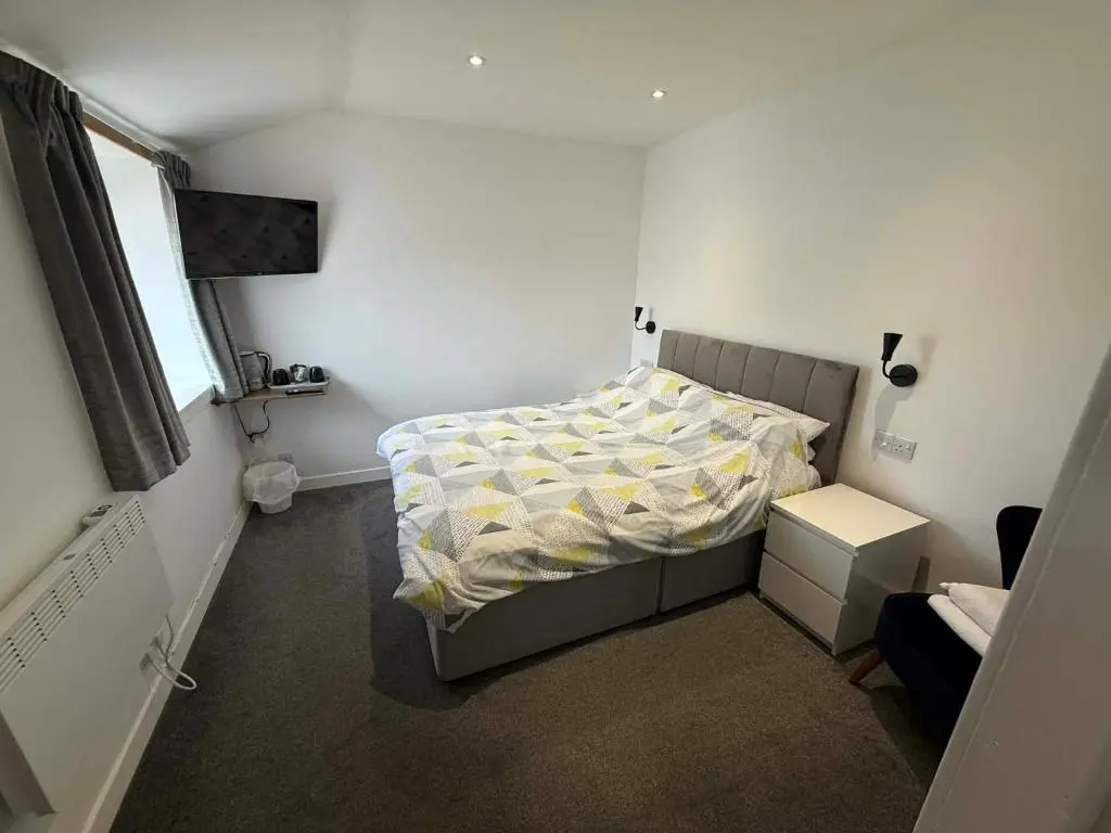 a small bedroom with a bed and a window at The Carisbrooke in Forres